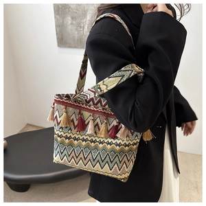 Detailed view of large ethnic tote bag featuring colorful geometric patterns and fringe tassels