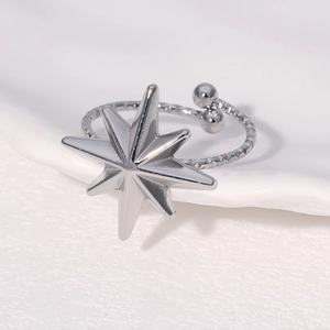 Macro shot of silver eight-pointed star ring with embossed textured band and adjustable open end