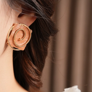 Close-up of vintage brown square resin earrings with gold spiral metal frames on model