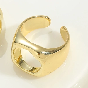 Macro shot of chunky 14K gold plated adjustable ring with hollow design on white background