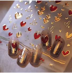 Macro detail of M-551 nail stickers featuring red hearts and gold crowns on faux nails