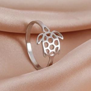 Polished stainless steel turtle cutout ring with silver finish on peach silk background