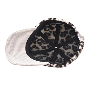 Detail view of corduroy brim and leopard print fur lining with metal adjustment buckle