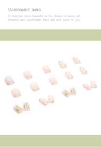 Flat lay of pink press-on nails with white flower patterns and green geometric accents