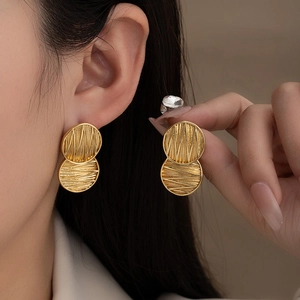 Golden double disc stud earrings with geometric rays and brushed texture for women