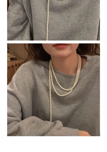 Detail view of multi-layer pearl necklace showing tiered styling on model neck