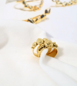 Macro detail of vintage embossed gold ring with intricate bohemian style coin relief