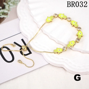 Detail of neon yellow Hamsa Hand charms and cubic zirconia on golden pull bracelet
