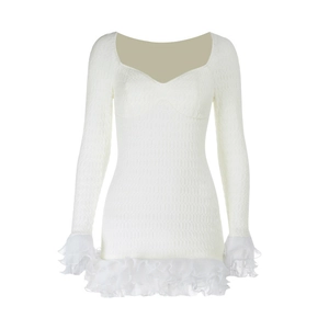 Detail of white long sleeve dress showing textured chiffon fabric and ruffled edges