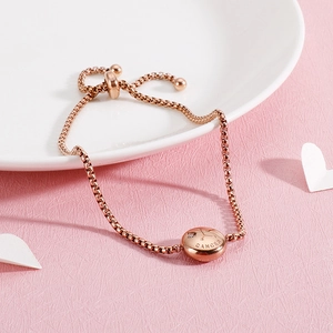 Detail of rose gold Cancer zodiac bracelet with engraved charm and adjustable slider