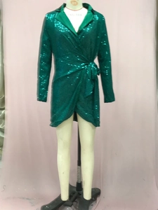 Dettaglio ravvicinato delle paillettes verde smeraldo e della cintura in vita dell'abito