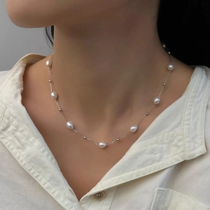 Close-up of elegant freshwater pearl necklace worn on model with white shirt