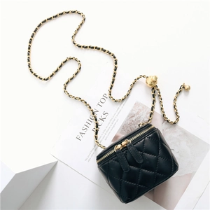 Detail of black quilted leather vanity bag with golden ball adjustable chain strap