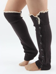Detail of dark knitted leg warmers featuring delicate white lace trim and black buttons