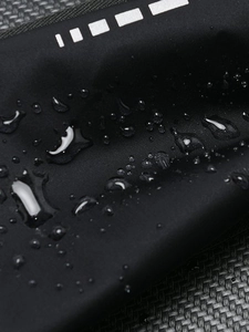Waterproof running waist pack with reflective strip showing water droplets on black fabric