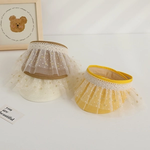 Detail of kids sun visor straw hat with yellow lace edges and glitter mesh ruffles