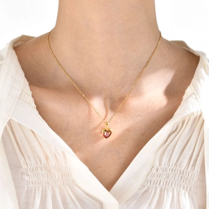 Dettaglio della collana con pendente a cuore dorato e pietra rossa termosensibile