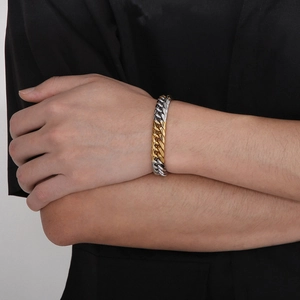 Close-up of dual-tone gold and silver Cuban link bracelet worn on a wrist