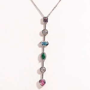 Macro detail of vertical linear pendant featuring colorful geometric crystals in silver setting
