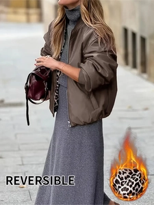 Detail of reversible leopard print bomber jacket and gray knitted skirt on a street setting