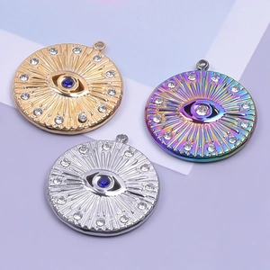 Detail of evil eye pendants in gold, silver, and rainbow finishes with blue crystals