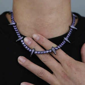 Detail of 5mm tennis chain necklace featuring purple crystals and sharp spike charms