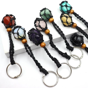 Detailed view of woven mesh keychains with various natural raw stones and wooden beads