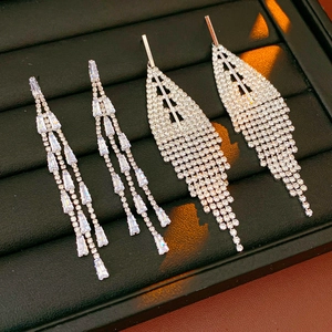 Close-up of silver tassel earrings with crystal fringe details in a black jewelry box