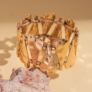 Vue détaillée du bracelet cœur doré élastique avec texture métallique martelée vintage