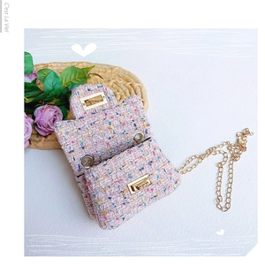 Nahaufnahme der rosa Tweed-Struktur mit goldenem Metallverschluss der Mini-Kettentasche