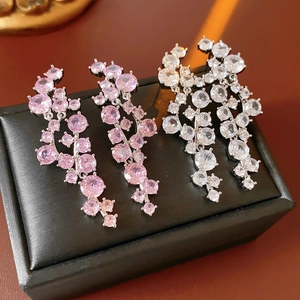 Macro detail of silver drop earrings with pink and clear cubic zirconia in a jewelry box