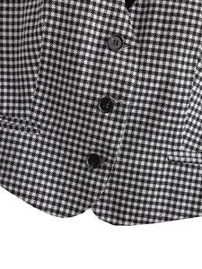 Gros plan du tissu pied-de-poule d'un gilet avec trois boutons noirs et texture premium