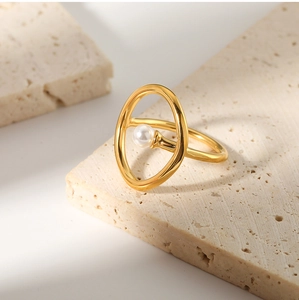 Detailed macro view of an elegant 18k gold pearl ring on a beige travertine stone base