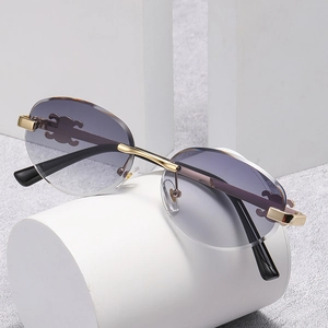 Detalle de lentes degradadas púrpuras y puente de metal dorado en gafas sin montura