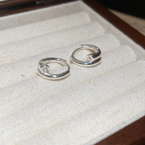 Vue macro de créoles en argent serties de pierres dans une boîte à bijoux en velours