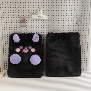 Detailed view of plush 11-inch devil tablet sleeve showing embroidered monster facial features