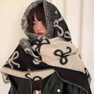 Thick black and white knitted scarf with infinite bow pattern for winter warmth