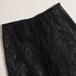 Gros plan détaillé du pantalon en dentelle noire avec texture de ceinture élastique