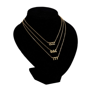 Close-up of triple layered gold angel number necklace with 222 444 777 pendants