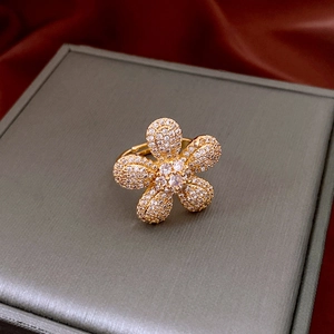 Detail of vintage gold flower ring with zircons on red silk background