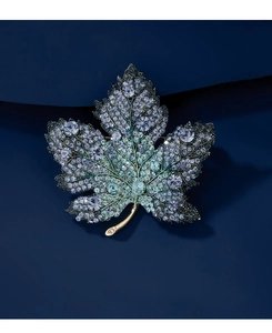Macro detail of luxury crystal maple leaf brooch with blue-green gradient rhinestones