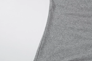 Macro shot of side seam stitching on grey knit fabric with detailed needlework