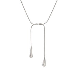 Détail macro du collier en Y en maille serpent argentée avec pendentifs goutte d'eau