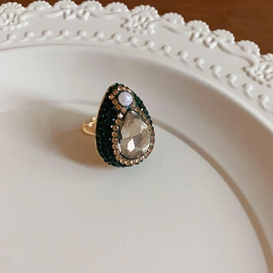 Macro shot of vintage gold-plated ring with teardrop zircon and green rhinestones