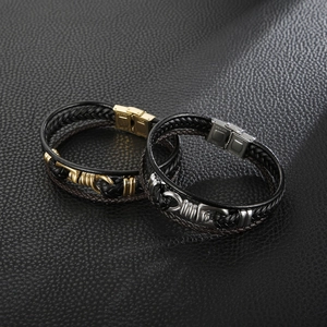 Detail of multi-layer black braided leather bracelet with gold and silver stainless steel clasps