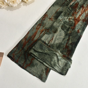 Dettaglio del tessuto a maglia tie-dye verde militare con trame marroni e cuciture rinforzate