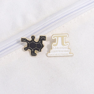 Close-up of caffeine molecule and Pi symbol enamel pins on a white canvas bag