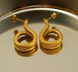 Macro shot of 18K gold plated snake stud earrings showing detailed scale texture