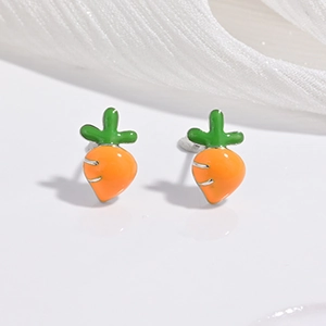 Vue détaillée des boucles d'oreilles carottes avec émail orange et vert sur fond de tissu