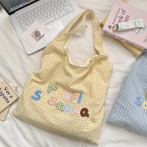Detail of yellow plaid tote bag featuring colorful Pearl Suzakka letter embroidery